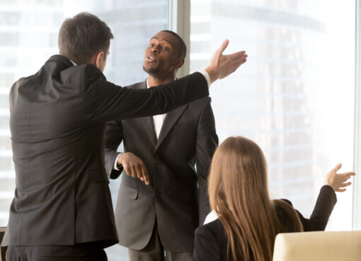 Business professionals arguing in office, symbolizing a commercial dispute requiring expert litigation services.