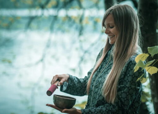 smiling-young-woman-holding-bowl-by-lake