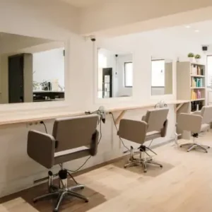 Modern hair salon interior with stylish chairs, large mirrors, and bright natural lighting, featuring a clean and minimalist design